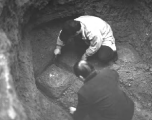 Two people excavating a tomb.