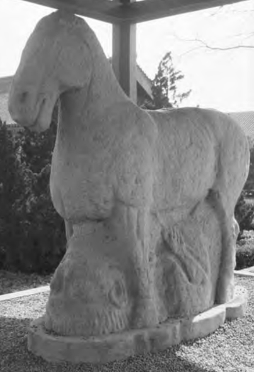 Statue of a horse over a foreign man