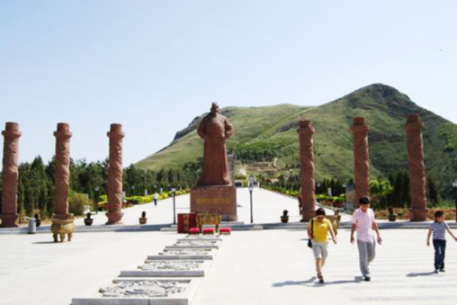 Statues and columns in front of the pathway to the tomb in the mountain.